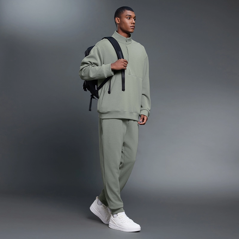 MZ-MWP002 | Wholesale Men's Joggers: 300G Brushed Air-Layer Fabric & Secure Back Zip Pocket - Iron Mountain Green - muzyoga 5 Man wearing Iron Mountain Green thermal joggers outdoors.