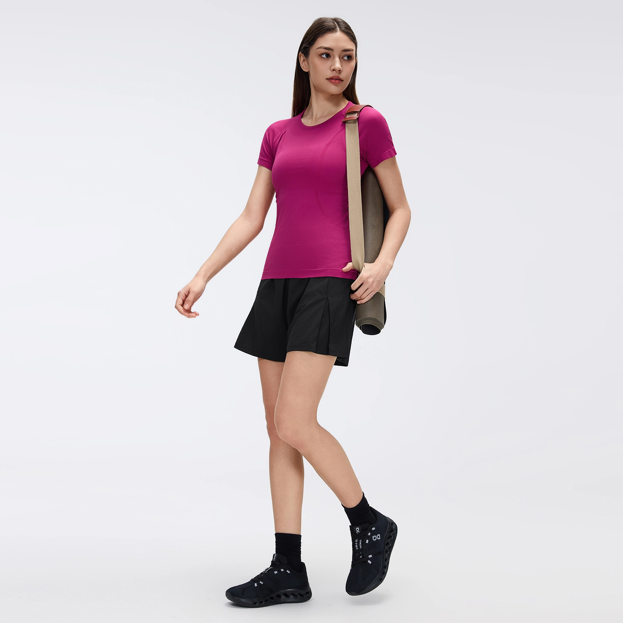 MZ-2067 | Wholesale Seamless Performance Tee: 160G Breathable Nylon & Back Ventilation - Smoky Magenta - muzyoga 4 Lifestyle view of MZ-2067 during pre-workout stretching at the gym.