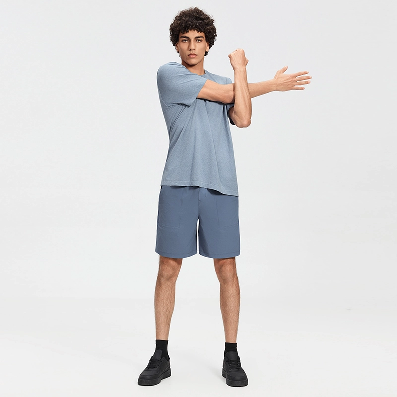 MZ-MS003 | Wholesale Men's Tech Casual Shorts: Water-Repellent 4-Way Stretch & Secure Zip Pocket - Washed Denim Blue - muzyoga 6 Man wearing Washed Denim Blue water-repellent shorts outdoors.