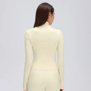 Back view of a Cream Yellow fitted workout jacket showing the curved upper-back seam, shaped waist panels and long sleeves.
