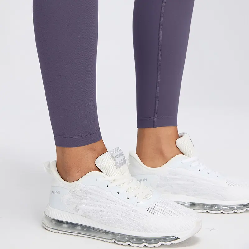 Women's High-Waisted No-Front-Seam Yoga Leggings 5 Close-up of the finished ankle hems and leg seams of Deep Purple leggings worn with white trainers.