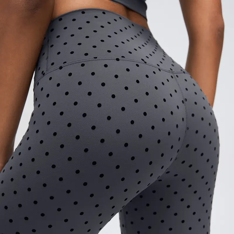 Women's High-Waisted Flocked Polka Dot Leggings 4 Close-up of the rear hip area of Gray flocked polka dot leggings, showing curved back panel seams and the dotted fabric surface.