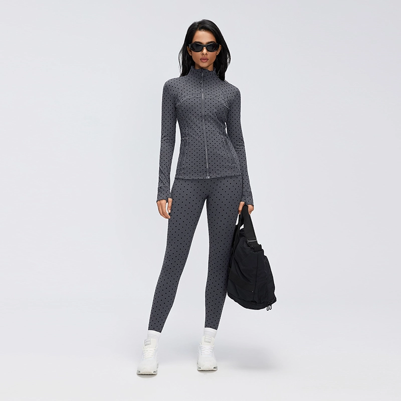 Women's High-Waisted Flocked Polka Dot Leggings 6 Full-length model wearing Gray flocked polka dot leggings with a coordinating zip-up workout jacket, white sneakers and a black sports bag.