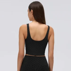 Back view of a black flocked polka dot crop tank top showing wide straps, a low U-shaped back and straight cropped hem.